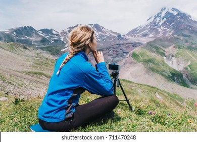 Girl Looking On A Tall Mountain With Mobile Phone On Tripod