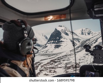 Girl looking out on a snowy crater mountain from a helicopter