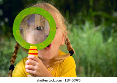 Girl looking through a magnifying glass