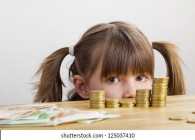 Girl looking at towers of money - Powered by Shutterstock