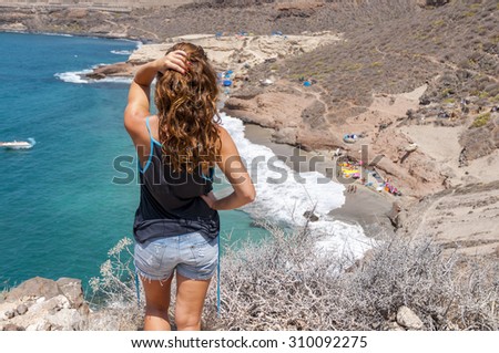 Girl looking at the wild beach in the south of Tenerife. Canarian Islands, Spain