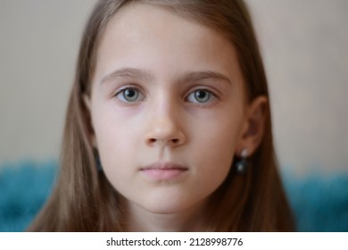 The girl looks with her eyes wide open. The girl has big clear, blue eyes