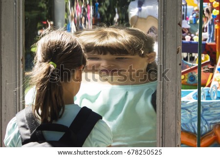 the girl looks at herself in the mirror, sees himself reflected in another form.