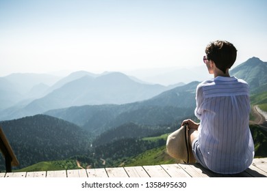 The girl looks at the mountains. Sochi. Krasnaya Polyana. Summer.