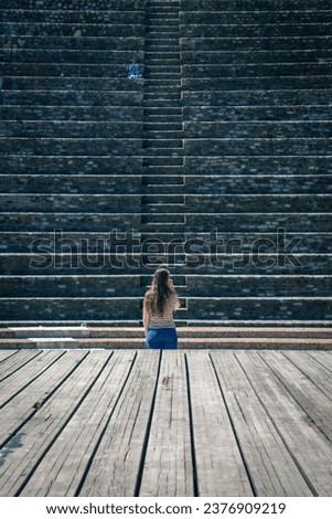 A girl looks at the staircase of an ancient Roman amphitheater. 