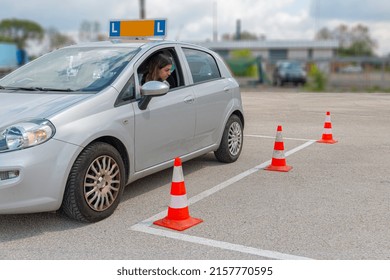 Girl loooking at cones trying to orientate at parking at practise for driving test. - Powered by Shutterstock