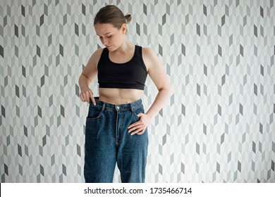 The Girl Lost Weight And The Old Jeans Became Large In Size. Comparison, The Result Of Diet, Nutrition And Sports At Home. Online Trainer Nutritionist. Measure Clothes. Not Fit Size Natural Appearance