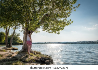 Girl in love watching the sunset on the lake - Shutterstock ID 1132922378