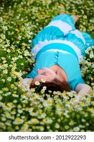 the girl is lying in a chamomile field