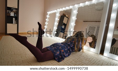 The girl is lying in front of the mirrors and flirting with herself. Manufacture of make-up mirrors.