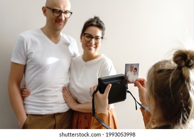 Girl Made A Photo Of Her Parents Using  Instant Camera At Home