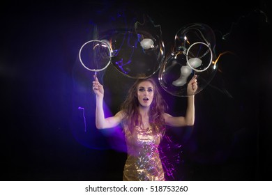 A Girl Makes Big Soap Bubbles In A Black Studio