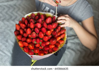 Girl makes a bouquet of strawberries. handmade