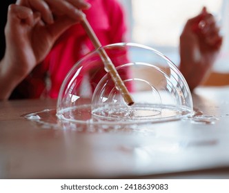 A girl makes bubbles inside a bubble 