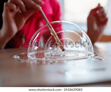 A girl makes bubbles inside a bubble 
