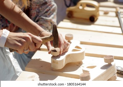 a girl makes a child's car out of wood - Powered by Shutterstock