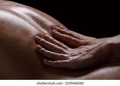 a girl makes a massage with oil close-up on a dark background - Powered by Shutterstock