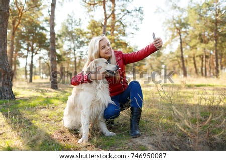 A girl makes selfie with her dog on a walk