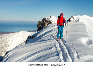 Girl makes ski mountaineering alone toward the mountain pass in a nice track with sealskin - Shutterstock ID 1307286217