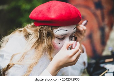 The Girl With Makeup Of The Mime. Improvisation. Suit For Halloween. Mime Shows Different Emotions. Sad Clown. A Female Mime Comedian Portrays Painting Her Face.