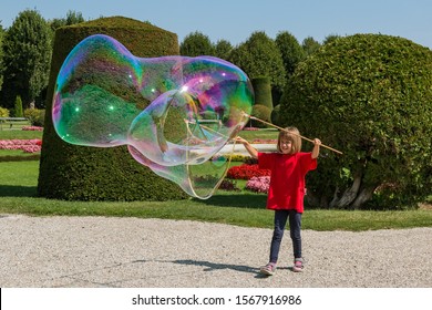 Girl Making Big Soap Bubbles In Park