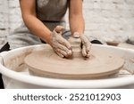 Girl is making a bowl on a pottery wheel with your own hands. Forming the proper size and shape of pottery with increasing speed of a pottery wheel