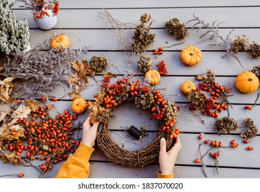 Girl Making Floral Autumn Door Wreath Using Colorful Rosehip Berries, Rowan, Dry Flowers And Pumpkins. Fall Flower Decoration Workshop, Florist At Work. 