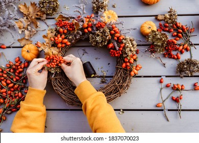 Girl Making Floral Autumn Door Wreath Using Colorful Rosehip Berries, Rowan, Dry Flowers And Pumpkins. Fall Flower Decoration Workshop, Florist At Work. 