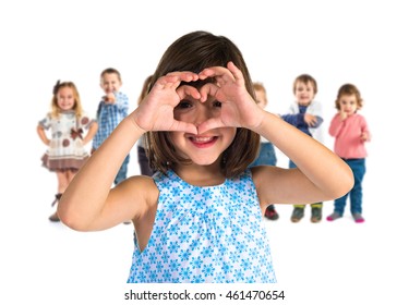 Girl Making A Heart With Her Hands  With Many People Behind