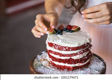 A girl making a homemade cake with an easy recipe, sprinkling sugar powder on top. Sitting sugar, strewed colander