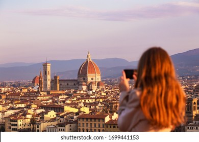 girl making a photo shoot of Florence with the smartphone. Cattedrale di Santa Maria del Fiore
