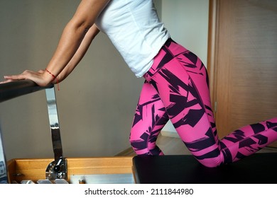 The girl is making remote exercise, indoor workout at her home, only body close up, no face, making reformer pilates, digital fitness  at home. - Shutterstock ID 2111844980