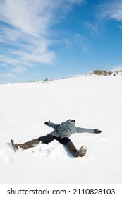 Girl Making Snow Angels In An Amazing Sunny Snowy Day.