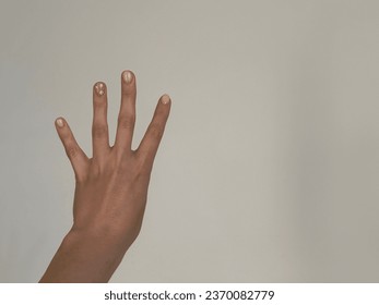 The girl with manicure shows four fingers on a white background - Shutterstock ID 2370082779