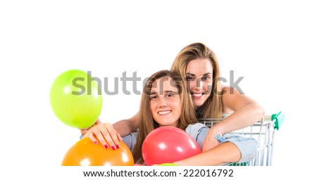 Girl with many balloons inside supermarket cart over white background