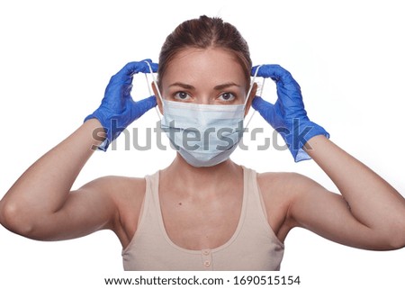 Girl in a mask and gloves with a sanitizer against the Coronavirus