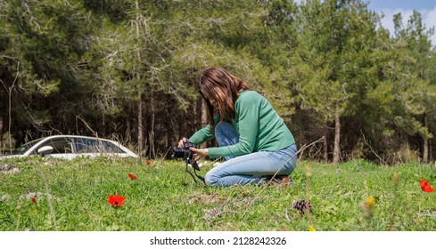 a girl in a meadow photographing flowers - Powered by Shutterstock