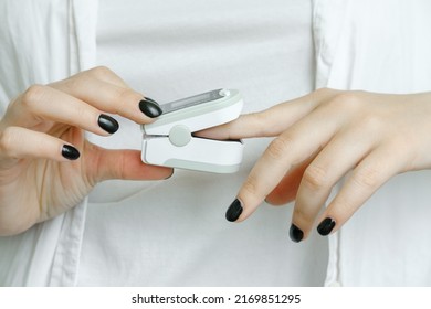 A Girl Measures Blood Oxygen Saturation Using A Pulse Oximeter Device On Her Finger