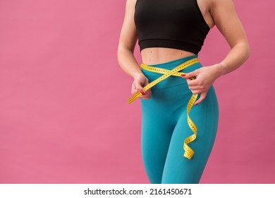 A Girl Measuring The Size Of The Waist. She Is Happy To See The Improvement In Body Shape Achieved Through Physical Exercise. And Proper Nutrition. Waist Measurement After A Diet. High Quality Photo