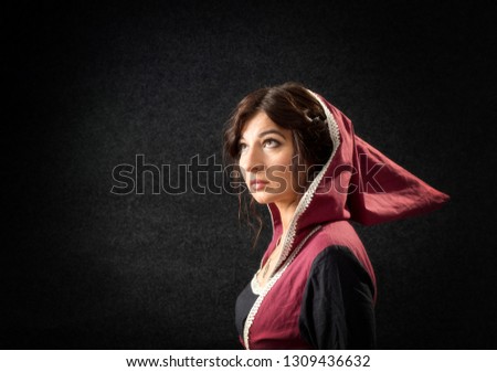 Girl in a medieval dress with a hood. Historical costume.