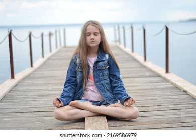 a girl meditates on the pier of the lake