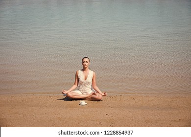 Girl Meditating, Sitting In Yoga Pose In Sea, Ocean Water On Sand At Sunny Summer Beach With Coffee Cup In Morning, Idyllic Vacation, Relax, Healthy Lifestyle