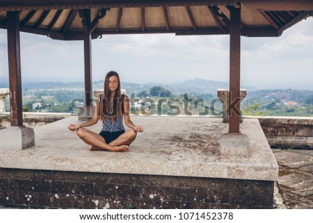 Girl meditation in a yoga pose in mountains on Bali,Indonesia