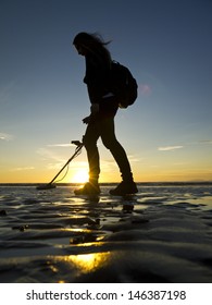 Girl With Metal Detector On The Beach.