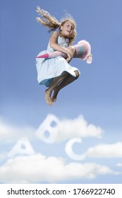 Girl in mid air jumping over ABC clouds