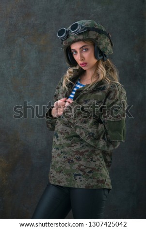 
Girl in military uniform with helmet and glasses
