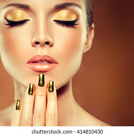 Girl Model With  Golden Makeup And Gold  Metal Manicure  Nails. Cosmetics,makeup And Beauty