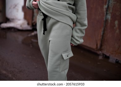 girl and model  on the street in oversized green hoodie.side view at a model in celadon color suit.fashion and wear concept.warm oversized wear,cloth,space for text and logo.mock up details.joggers - Shutterstock ID 2057615933