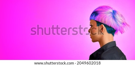 A girl with a modern asymmetrical hairstyle on a purple background [[stock_photo]] © 