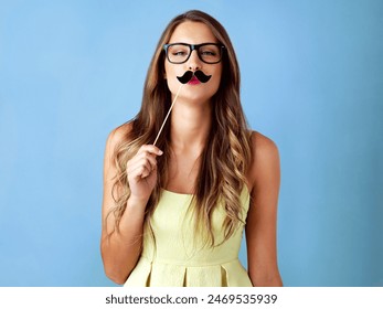 Girl, moustache and happy with prop in studio for pout, photo booth and comic icon with portrait on mockup. Woman, person and funny face with mask on stick for celebration and fun on blue background - Powered by Shutterstock